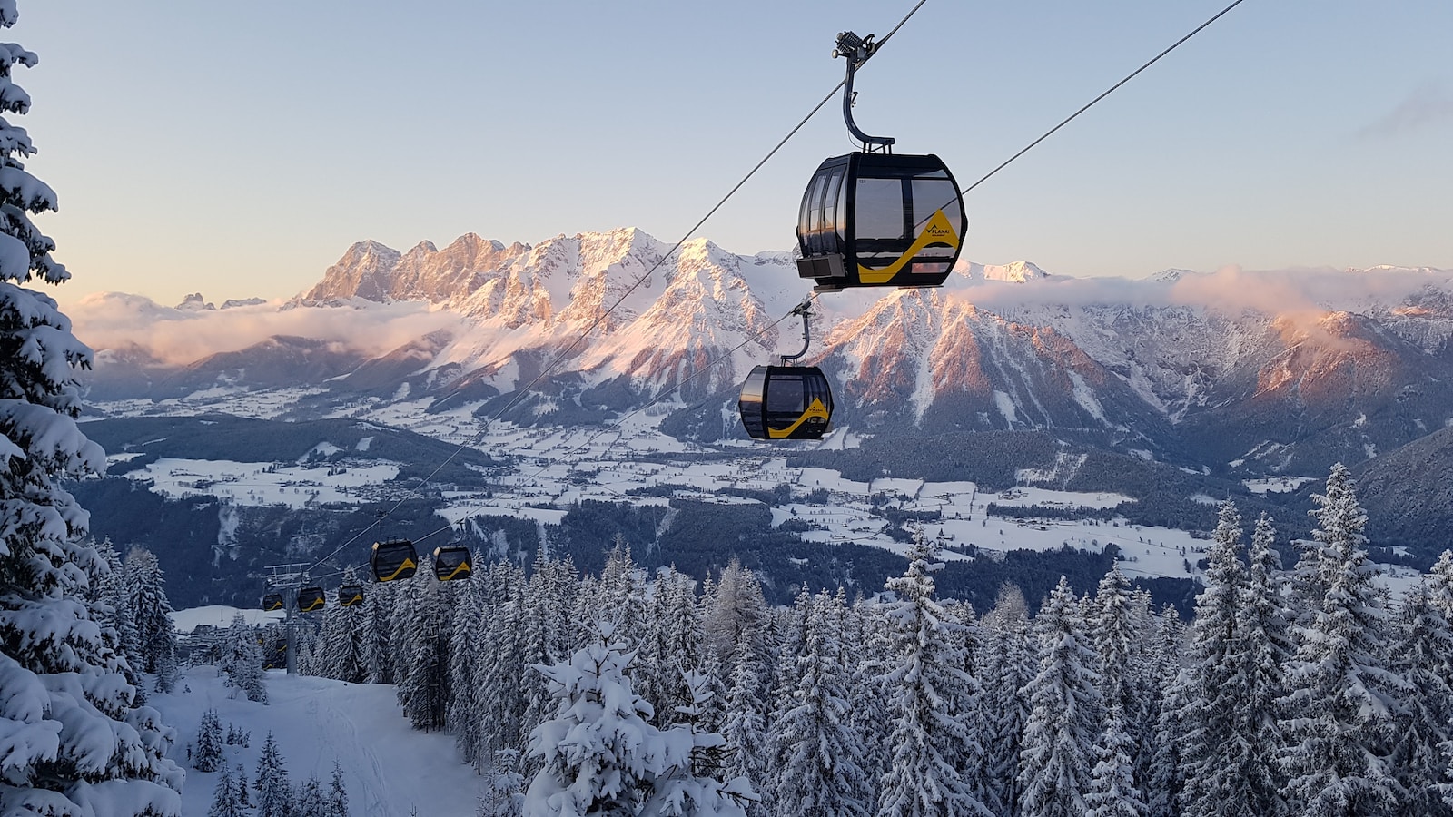 black cable car over snow covered mountain during daytime
